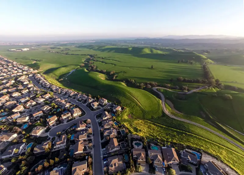 Aerial view of Antioch, CA neighborhoods bordering open hillside