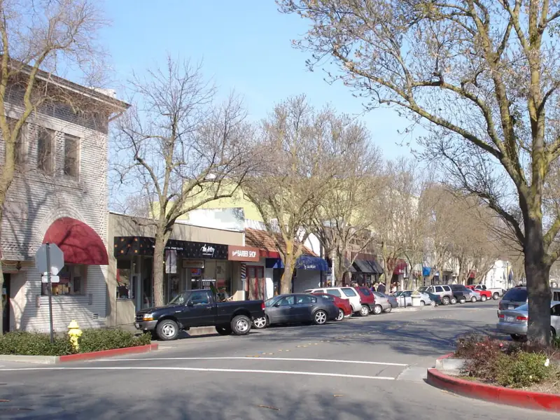 Historic downtown Davis, CA storefronts along a tree-lined street